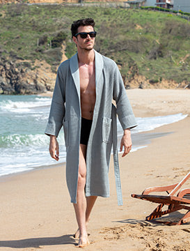 Man relaxing in a SEYANTE's Lightweight Robe on a beach.